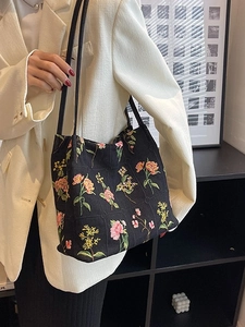 Fashionable black canvas bucket tote bag with colorful floral embroidery and shoulder straps
