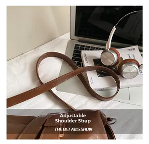 Detail view of the adjustable brown leather strap with metallic buckle and stitching