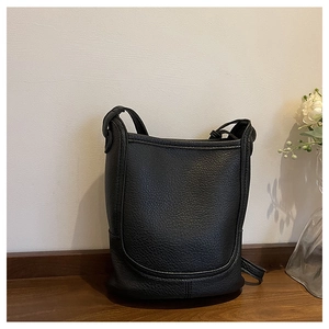 Detail view of black lychee grain leather bucket bag with signature U-shaped stitching