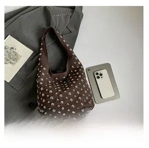 Confronto dimensioni della borsa hobo marrone con borchie insieme a un tablet
