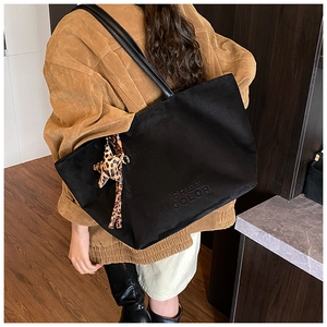 Close-up of black suede tote bag featuring FREE COLOR embossing and leopard star charm