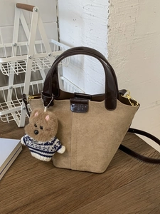 Khaki suede bucket bag with dark brown leather handle and cute puppy charm accessory