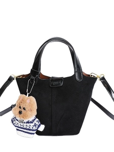 Classic black bucket bag in matte finish with leather handles and cute plush bear charm