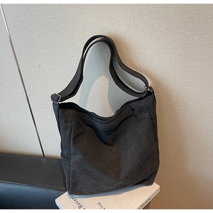 Dettaglio del resistente tessuto di tela grigio scuro su una borsa a tracolla versatile
