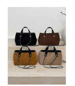 Four colors of suede chain bucket bags displayed on marble steps with minimalist decor