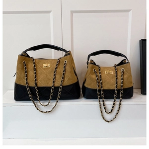Detail view of large and small quilted leather chain bags with suede contrast stitching