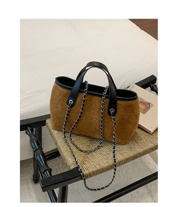 Detail of vintage brown suede tote bag featuring black trim and silver chain strap