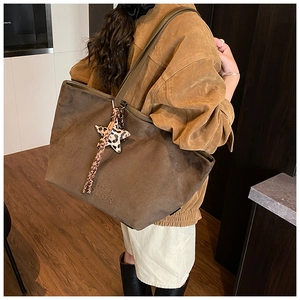Close-up of brown suede tote bag featuring FREE COLOR embossing and leopard star charm