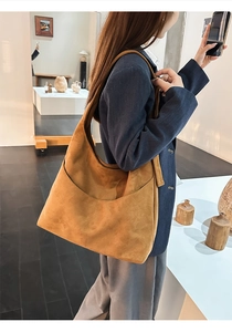 Sac fourre-tout en daim marron sur modèle, design rétro minimaliste et large bandoulière