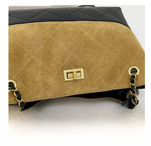 Close-up of golden metal turn-lock closure on quilted leather bucket bag with chain strap
