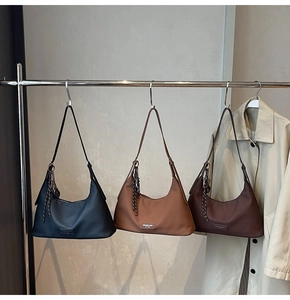 Detail view of three Maillard hobo bags hanging with braided rope charms and logo plaque