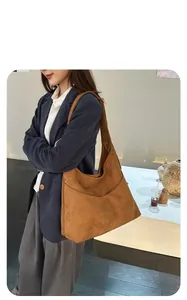 Détails du sac hobo en daim marron montrant la grande capacité et le porté épaule