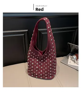 Dettaglio della borsa hobo scamosciata rosso scuro con borchie argentate e stile hobo