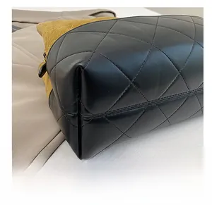 Detailed close-up of durable quilted leather base and yellow suede on a bucket bag