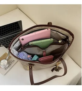 Detail view of spacious tote interior with zip divider holding a tablet and essentials