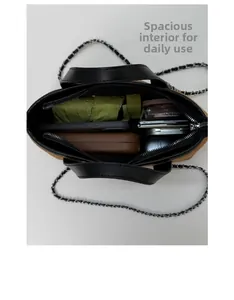 Top view of large suede tote bag showing spacious interior with daily essentials and chain