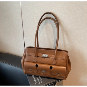 Close-up of caramel leather tote bag with triple front pockets and silver turn-lock hardware