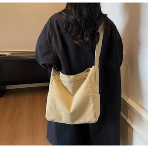 Dettaglio di una grande borsa a tracolla in tela kaki con tasca e tracolla larga