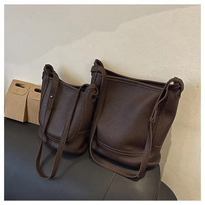 Detail showing two dark brown pebble leather bucket bags in large and small sizes