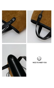 Macro view of brown suede tote bag with black leather trim, stitching and silver zipper