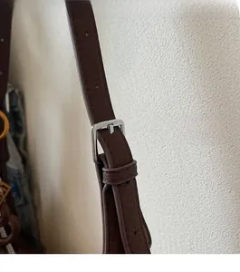 Close-up of adjustable dark brown lychee texture leather strap with silver metal buckle