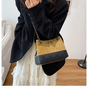 Detail of two-tone quilted leather bag with chain strap and metallic rotary lock