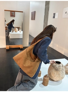 Sac cabas en daim marron sur mannequin avec design minimaliste dans une galerie d'art