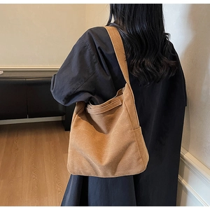 Dettaglio della borsa a tracolla in velluto a coste color cammello con trama vintage e capienza
