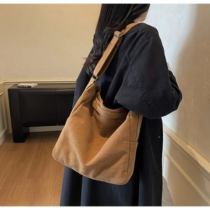 Dettaglio della borsa hobo in tela marrone scuro con ampia tracolla regolabile