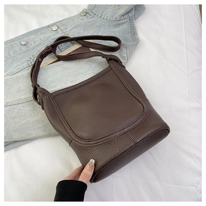 Detail shot of vintage dark brown lychee leather bucket bag with adjustable strap