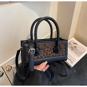 Detailed view of the leopard print texture and black leather stitching on the small square bag
