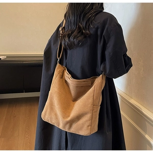 Dettaglio di una grande borsa tote in tela marrone con tracolla regolabile e finitura opaca