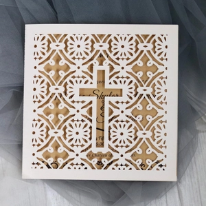 Laser-cut white wedding invitation with cross pattern and kraft paper inner sheet