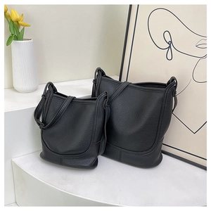 Detailed comparison of two black lychee-textured leather bucket bags in different sizes