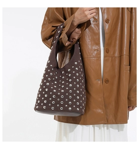 Dettaglio della borsa tote opaca marrone scuro con borchie argento vintage e stile hobo