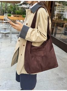 Détail d'un grand sac cabas en daim marron foncé avec coutures incurvées élégantes
