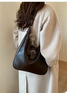 Détail du sac hobo marron foncé avec boucle argentée et breloque en peluche sur le modèle