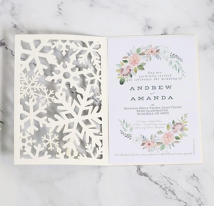 Invitation de mariage élégante découpée au laser avec flocon sur marbre blanc