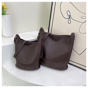 Detail of dark brown pebble leather bucket bags in two sizes on minimalist display