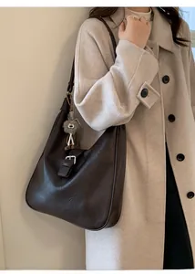 Détail du sac cabas marron foncé en similicuir avec boucle et pendentif peluche
