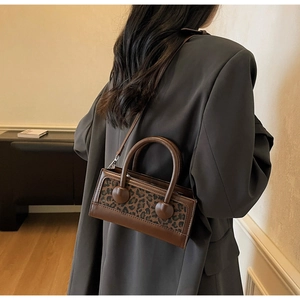 Detail of leopard print panel and brown leather texture on a chic shoulder bag