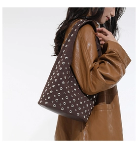 Dettaglio di borsa tote in tela marrone con borchie in metallo in stile vintage