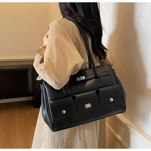 Macro view of black utility tote bag with silver metal twist locks and pocket details
