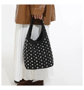 Dettaglio della borsa hobo in pelle scamosciata nera con rivetti argentati e borchie