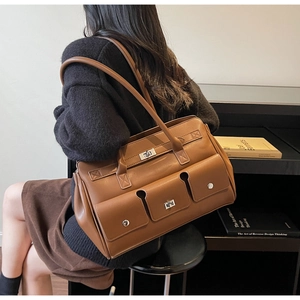 Detailed view of brown vintage leather shoulder bag with multiple functional buckle pockets