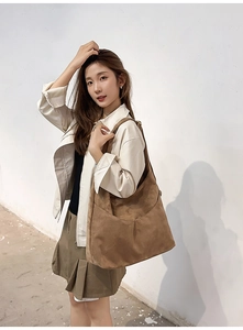 Détail du grand sac cabas hobo en daim marron porté par un mannequin sous une lumière douce