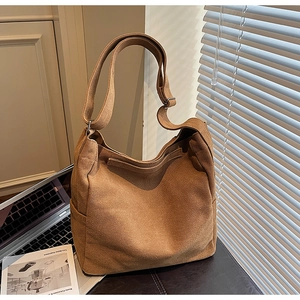 Dettaglio borsa hobo in tela marrone con tracolla regolabile e tasche laterali
