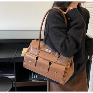Close-up of vintage brown leather shoulder bag featuring silver buckle and multiple pockets