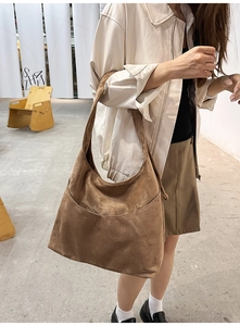 Vue latérale détaillée d'un grand sac cabas en daim marron porté par un mannequin chic