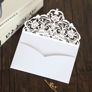 Detailed laser-cut heart and floral lace patterns on elegant white wedding invitations